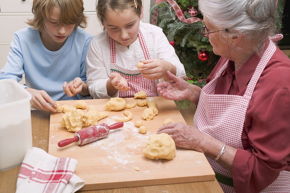 Grossmutter und Enkel bereiten Vanillekipferl zu