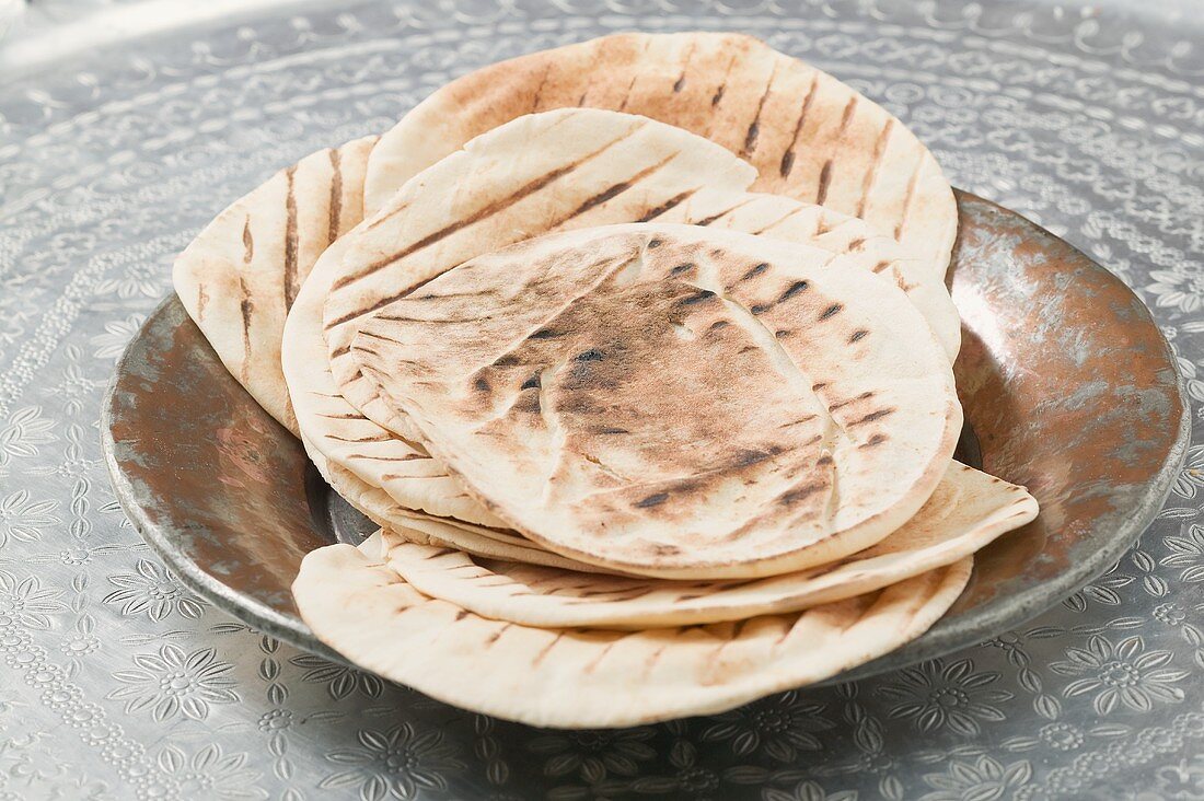 Grilled flatbread on metal plate