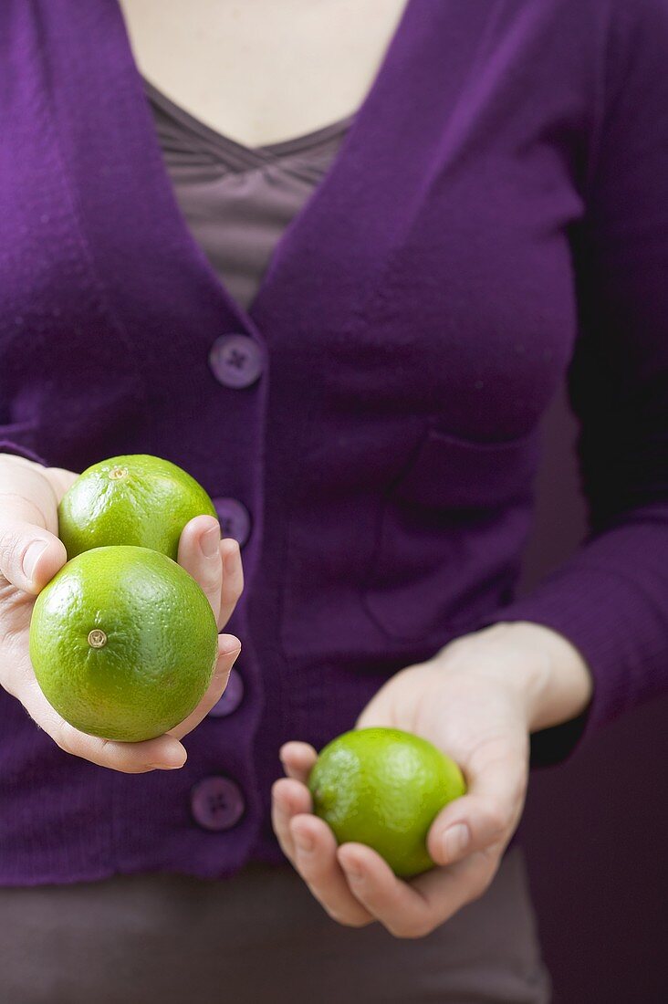 Woman holding three limes