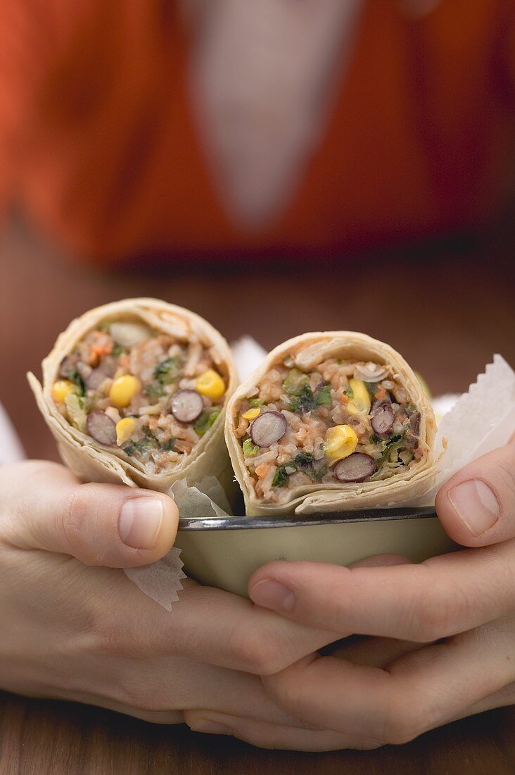 Woman holding bean burritos