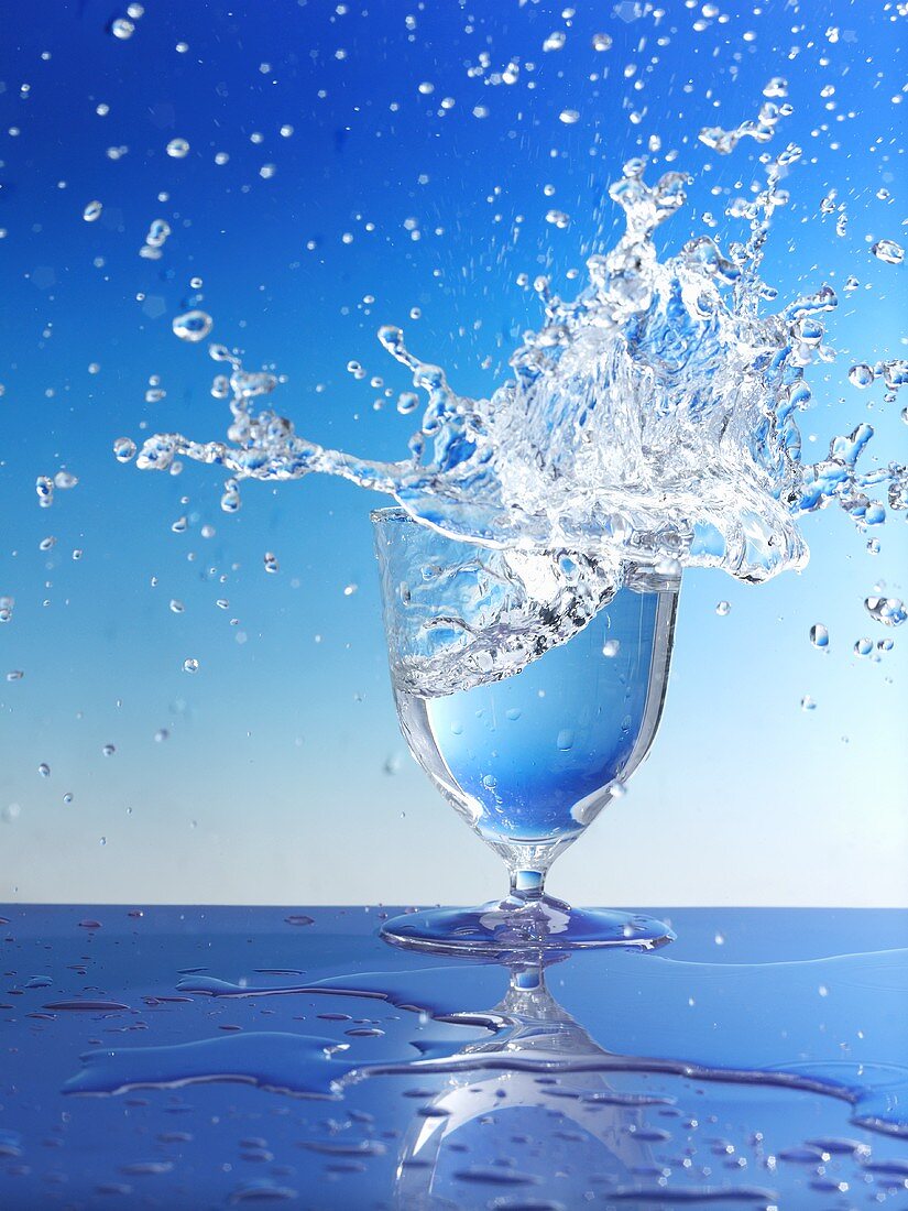Wasser spritzt aus Glas