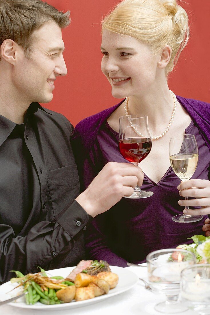 Elegantes Paar stösst mit Weingläsern an