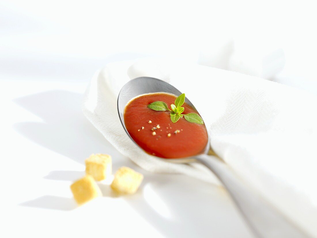 Ein Löffel Tomatensuppe, daneben Croûtons