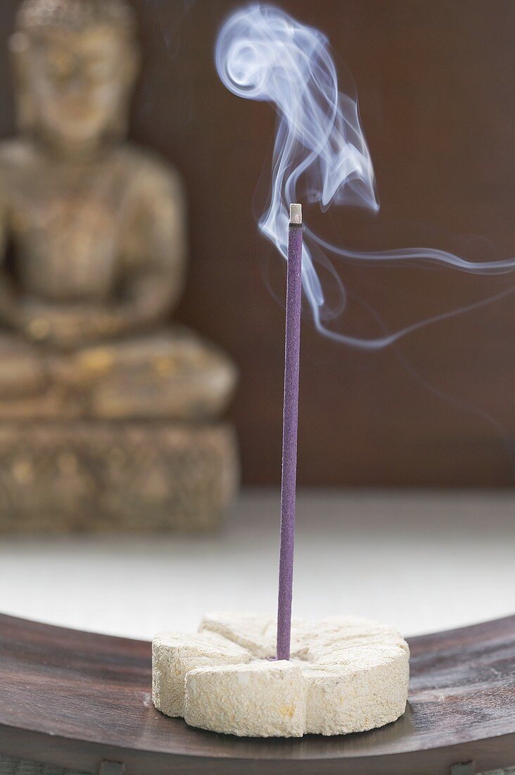 Incense stick in front of Buddha statue