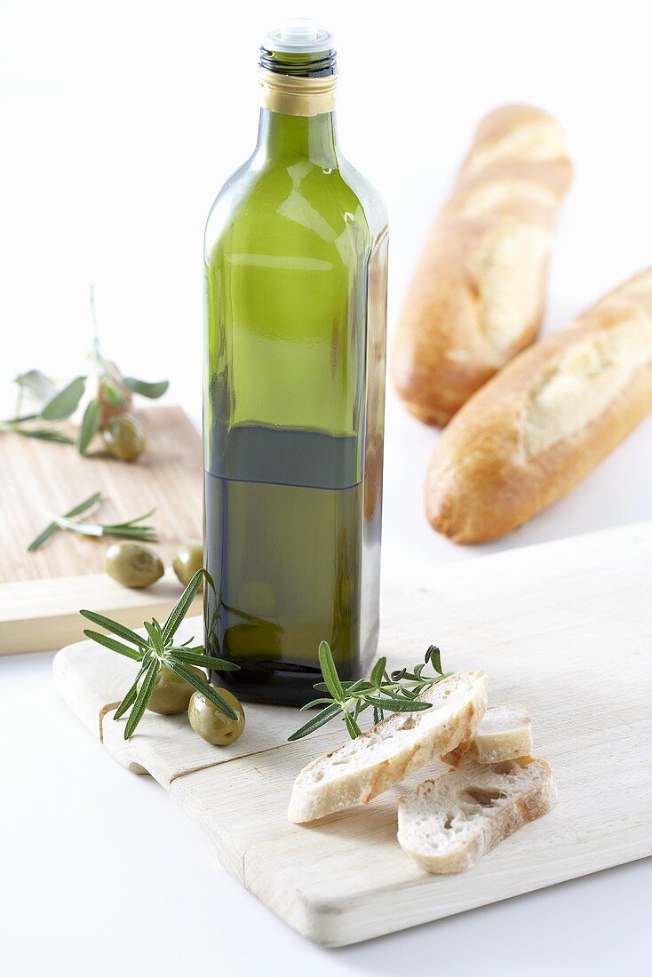 Flasche Olivenöl, Oliven, Rosmarin und Brot