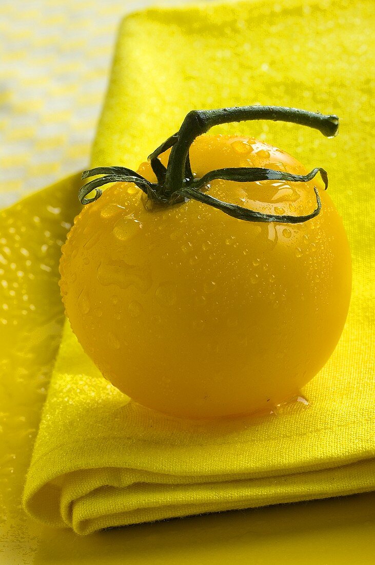 Gelbe Tomate mit Wassertropfen