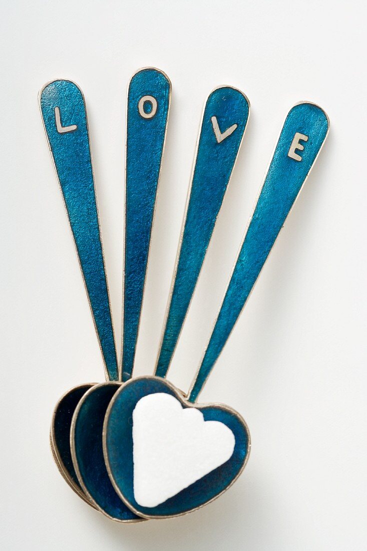 Herzförmige Löffel mit Zuckerwürfel und Schriftzug LOVE