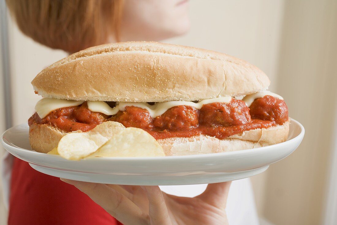 Woman serving a meatball sandwich