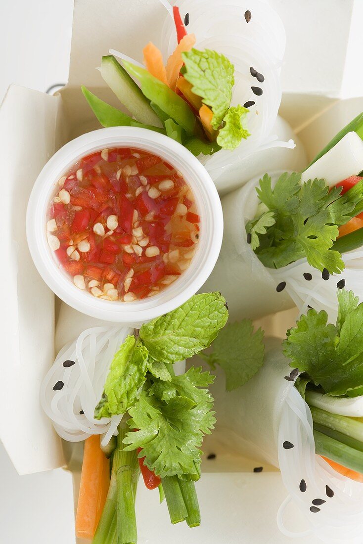 Rice paper rolls with vegetables & sauce in take-away container