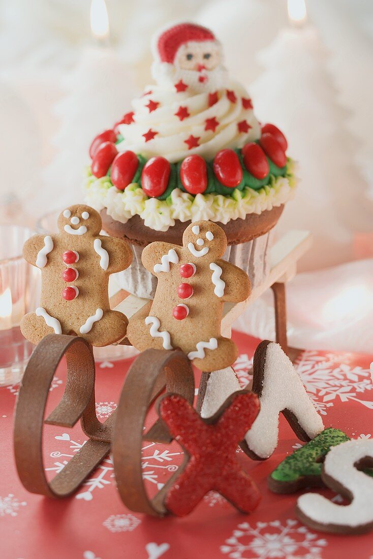 Cupcake und Lebkuchenfiguren auf kleinem Schlitten