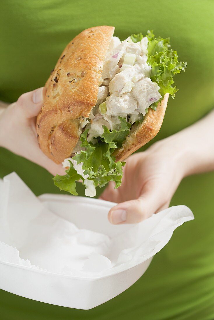 Woman holding take-away chicken sandwich
