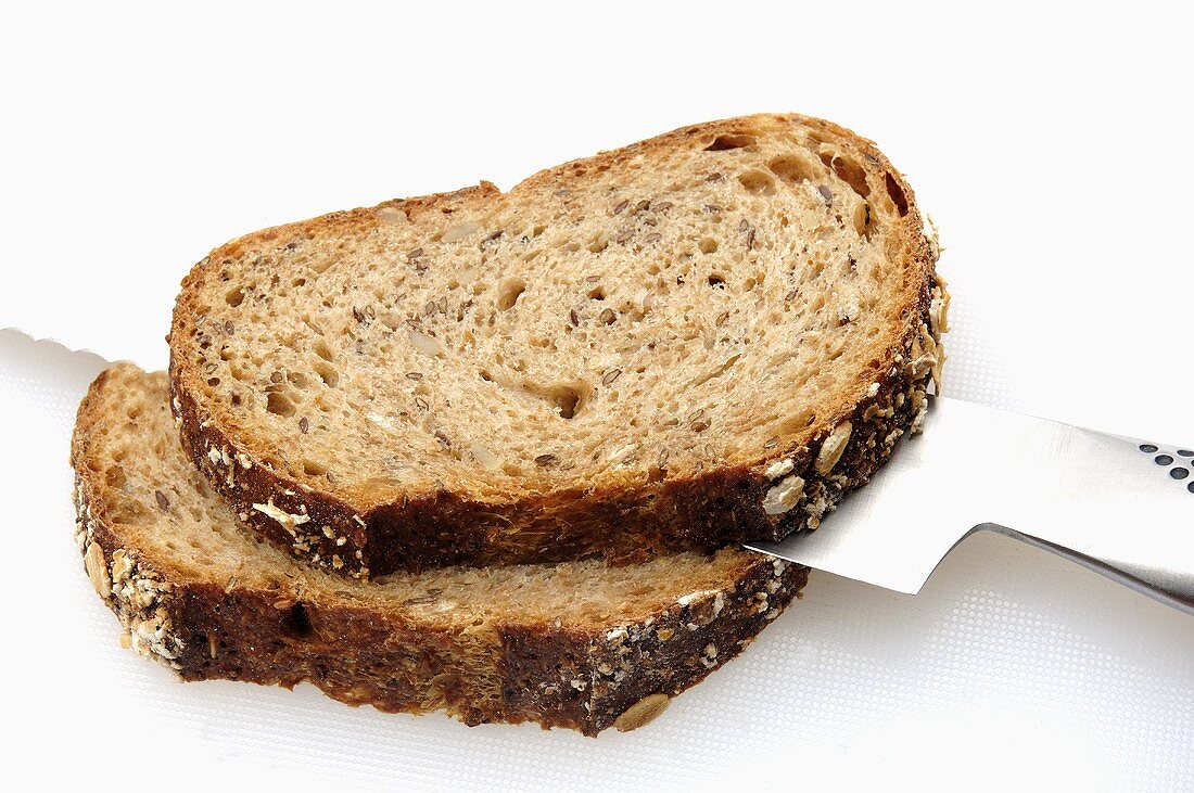 Two slices of multigrain bread with bread knife