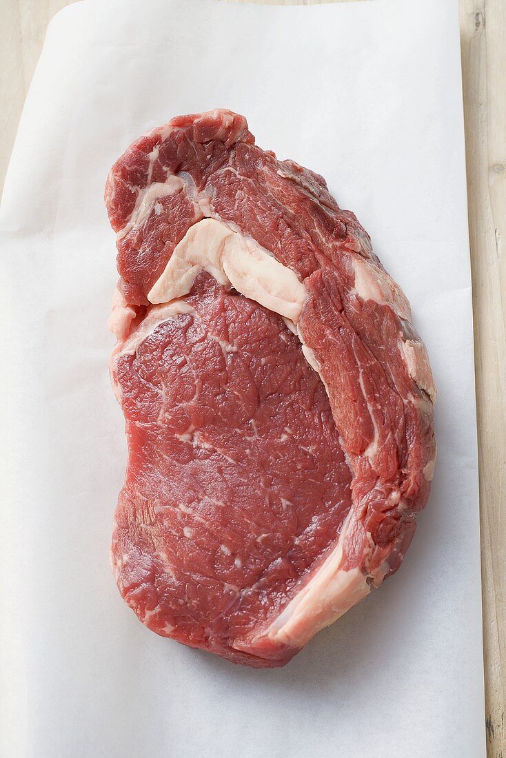 Raw beef steak on paper