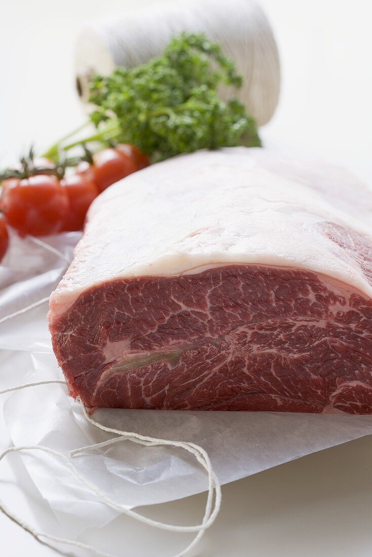 Frisches Rindfleisch auf Papier mit Küchengarn