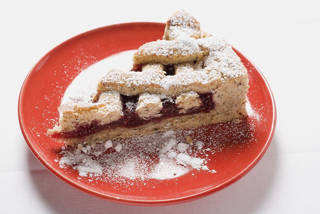 Piece of Linzer Torte with icing sugar on plate (Austria)