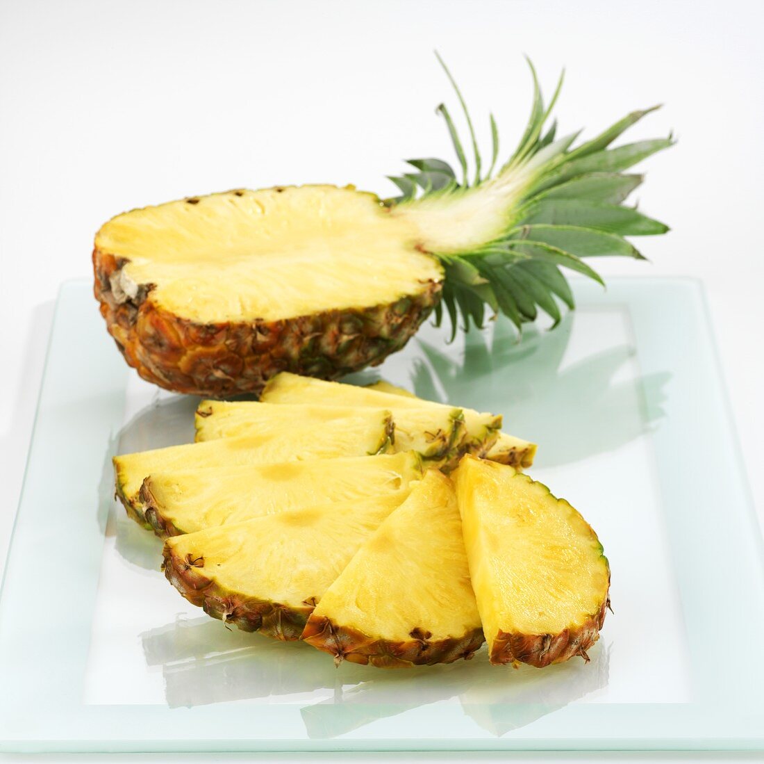 Half a pineapple and pineapple slices