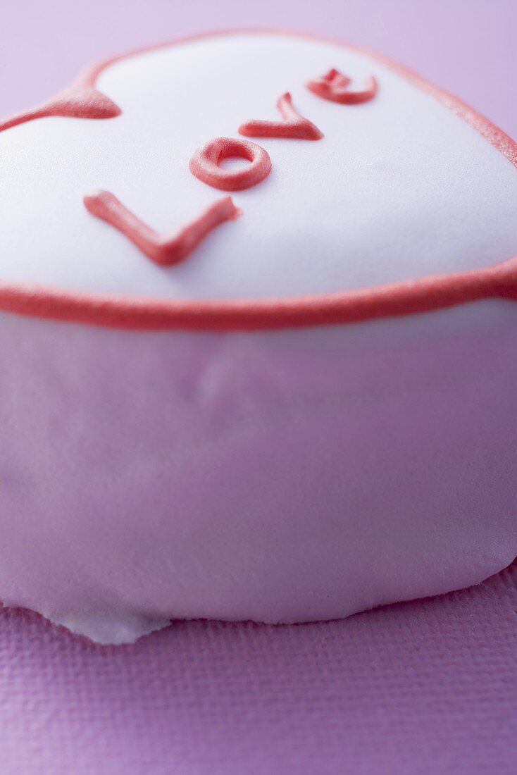 Pink heart-shaped cake with the word Love