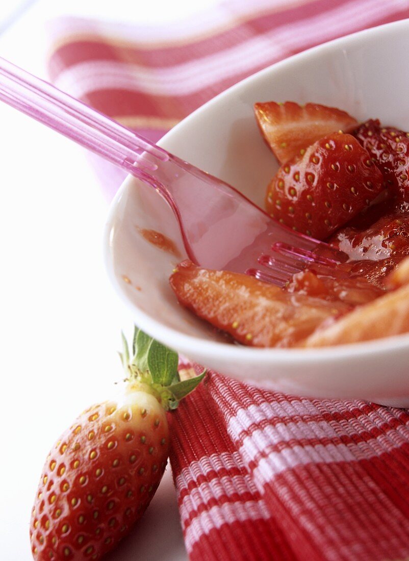 Erdbeeren mit Plastikgabel zerdrücken