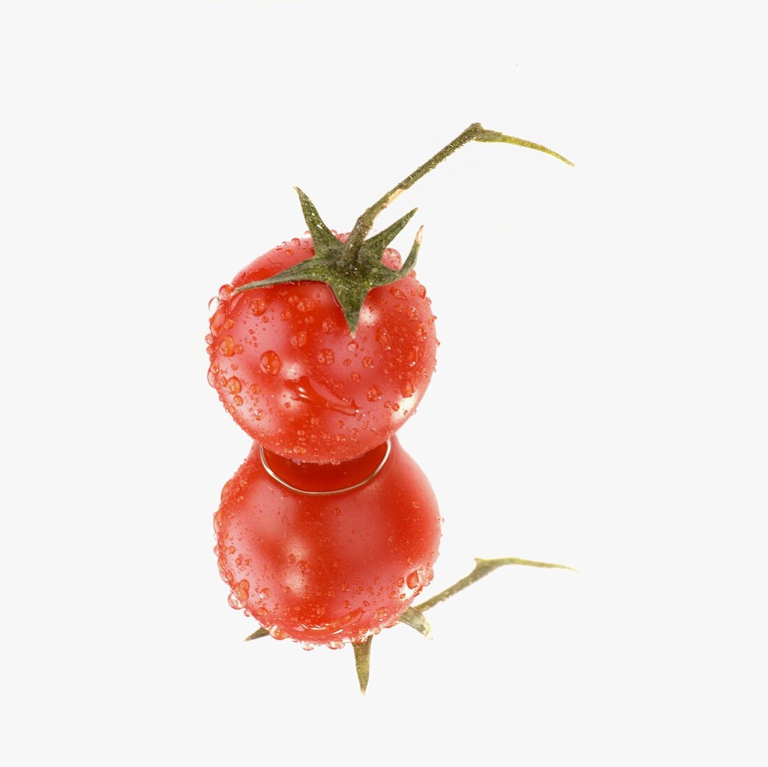 Tomato with drops of water on a mirror