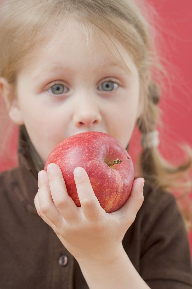 Kleines Mädchen beisst in Apfel