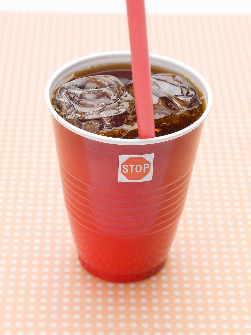 Cola with ice cubes in plastic cup