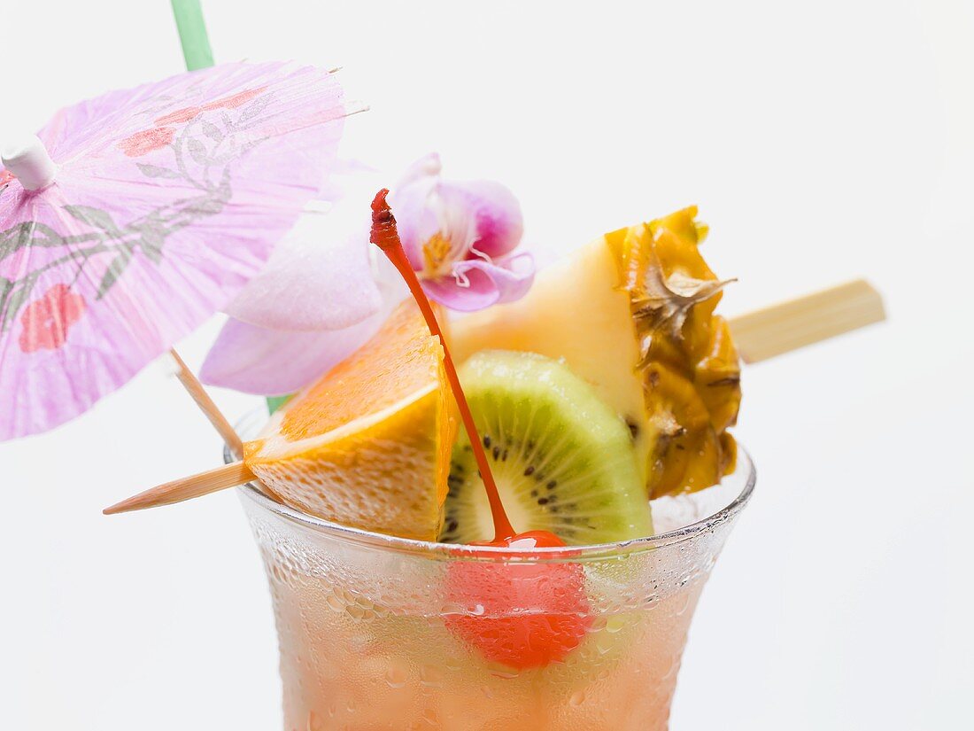 Cocktail with exotic fruit skewer and umbrella