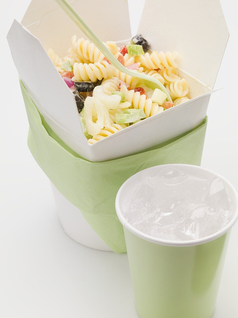 Fusilli with vegetables in take-away container, drink