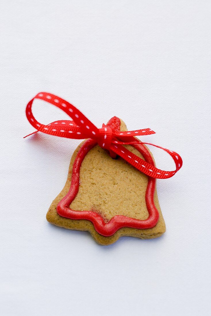 Glockenförmiges Weihnachtsplätzchen mit roter Schleife