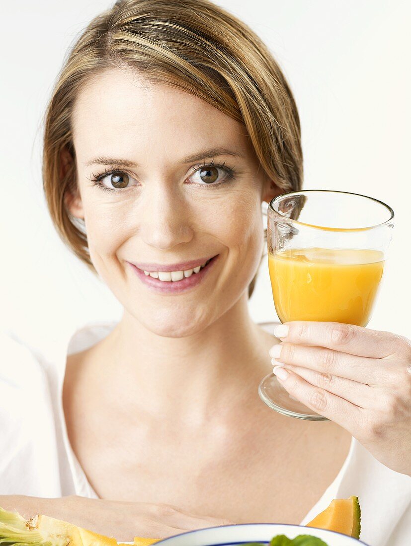 Frau hält Glas Orangensaft