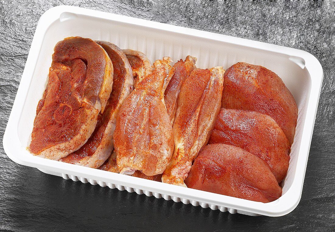 Seasoned poultry meat in plastic container