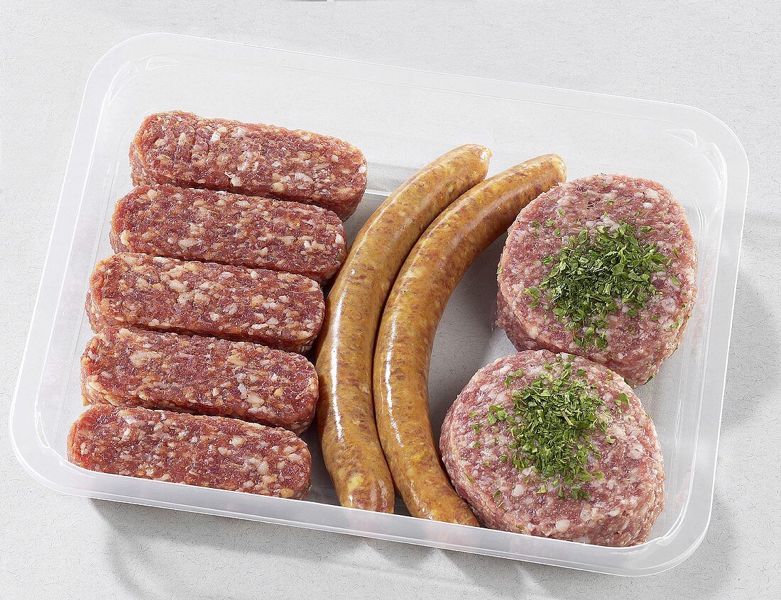 Cevapcici, sausages and burgers in plastic container