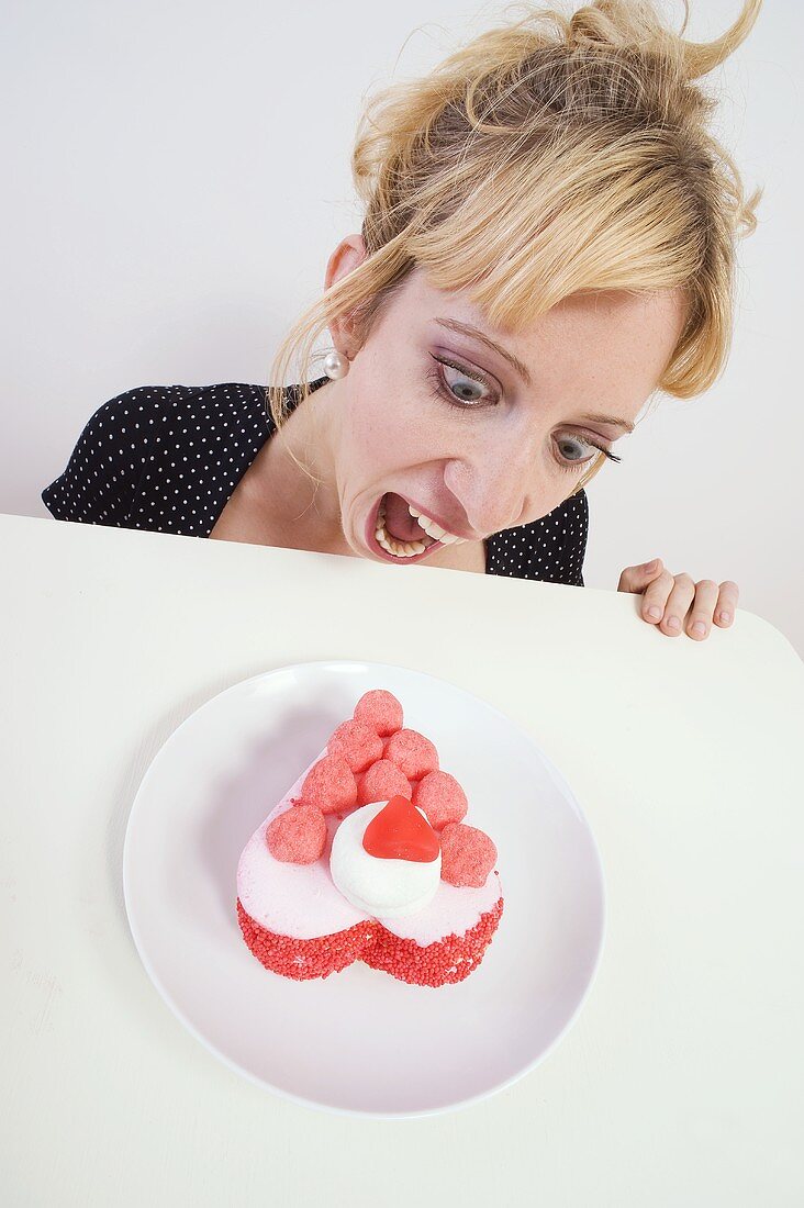 Ravenous woman looking at a small cake