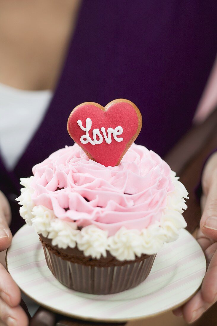 Frau hält Cupcake zum Valentinstag