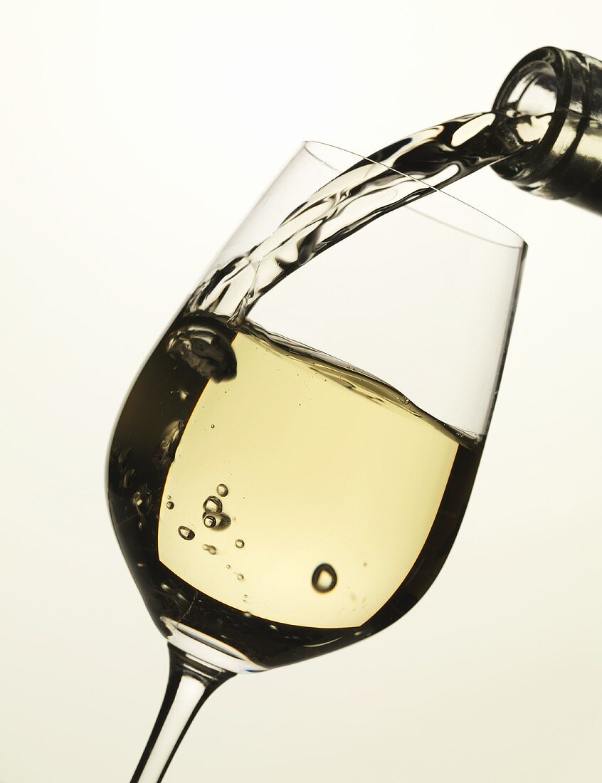 Pouring white wine into glass