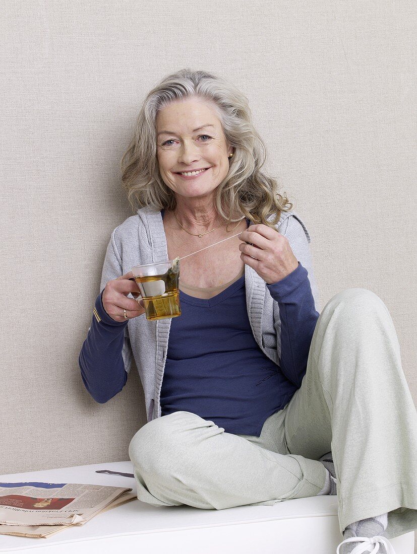 Ältere Frau mit einem Glas Tee