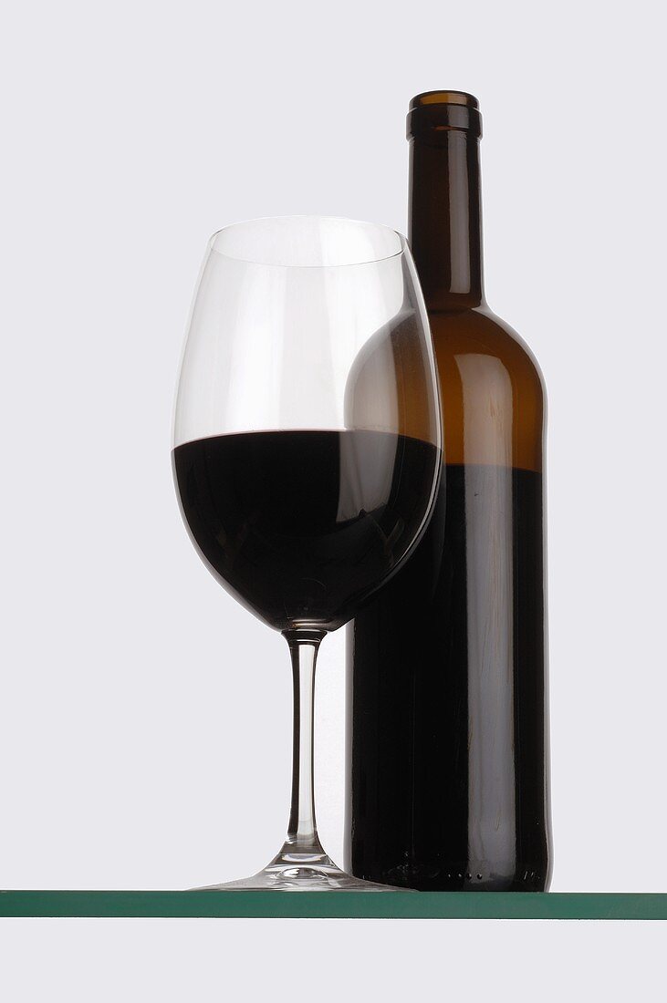 Rotweinglas und Flasche