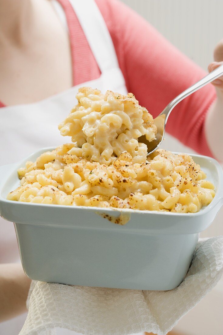 Frau serviert Macaroni and Cheese