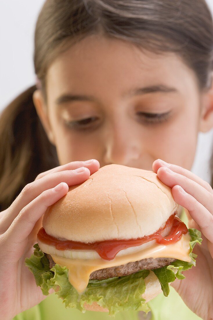 Little girl eating cheeseburger