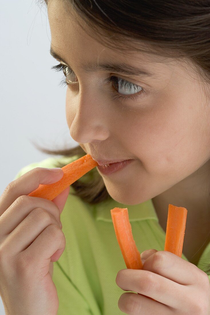 Little girl eating carrot sticks