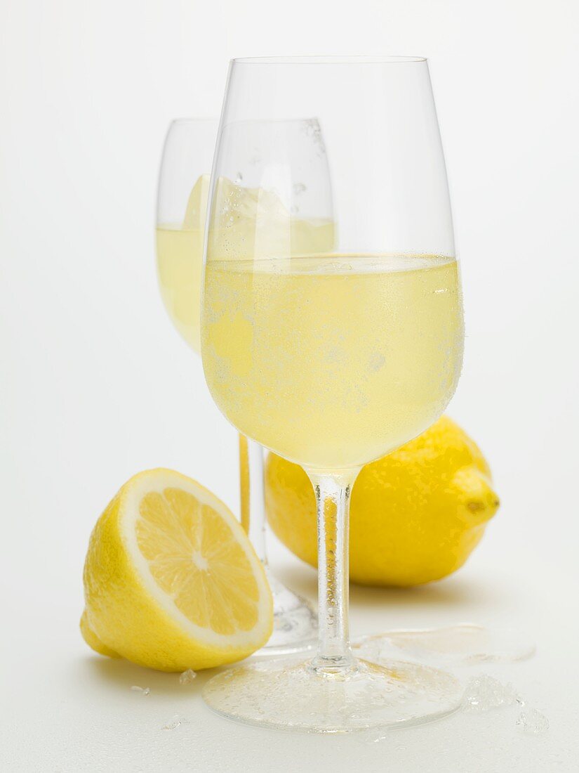 Two glasses of limoncello and fresh lemons