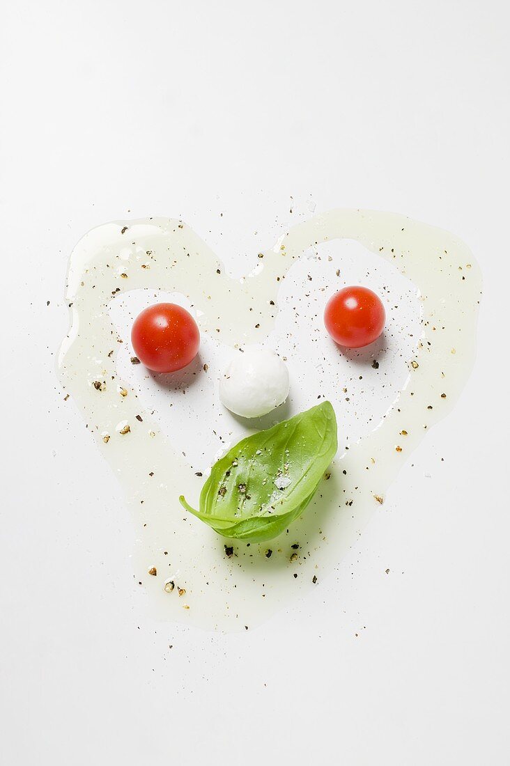 Tomatoes, mozzarella, basil, oil and spices forming a face