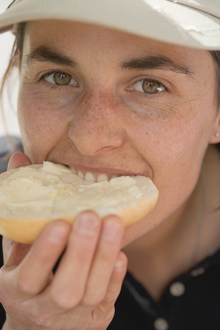 Frau beisst in ein Butterbrötchen