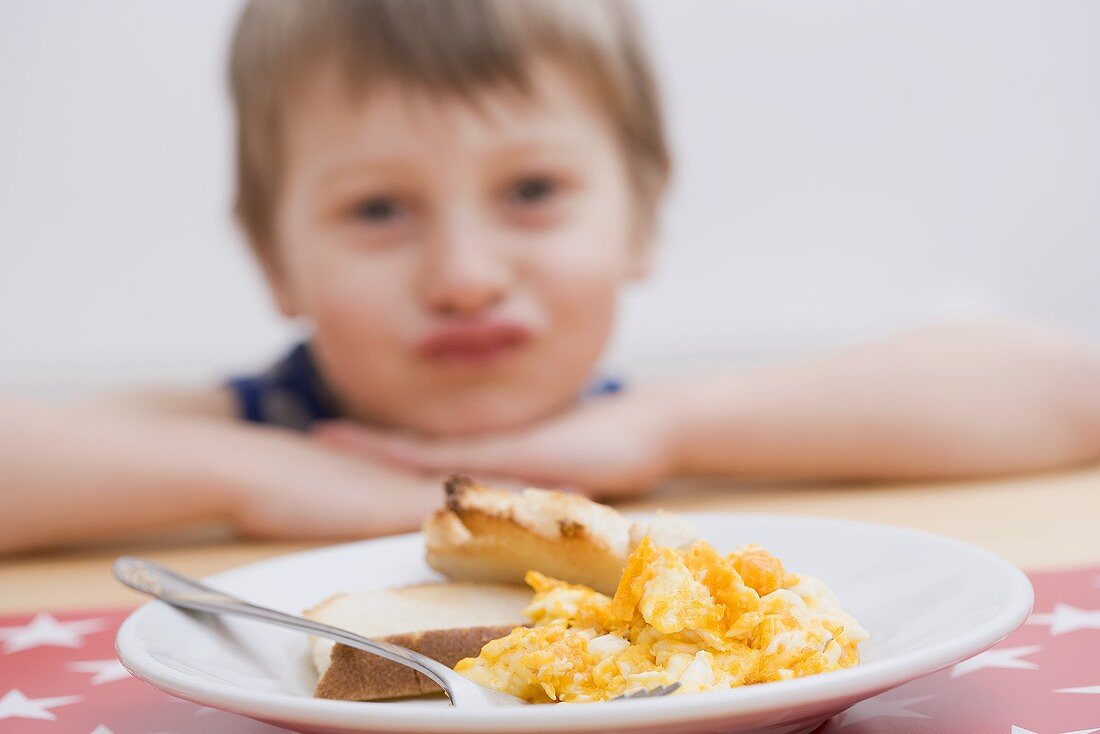 Rührei mit Toast, kleiner Junge im Hintergrund