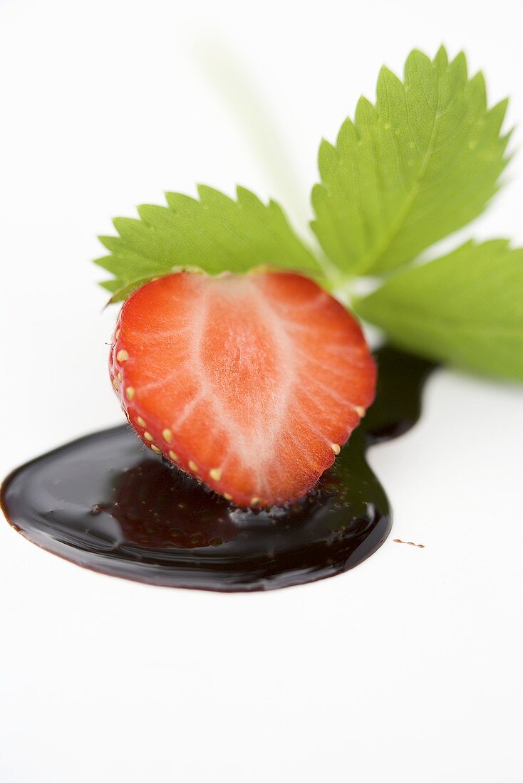 Half a strawberry with chocolate sauce and strawberry leaf