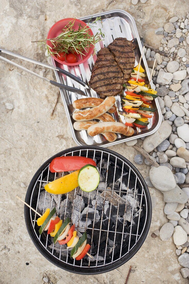 Vegetables on barbecue, meat, sausages, kebabs in dish