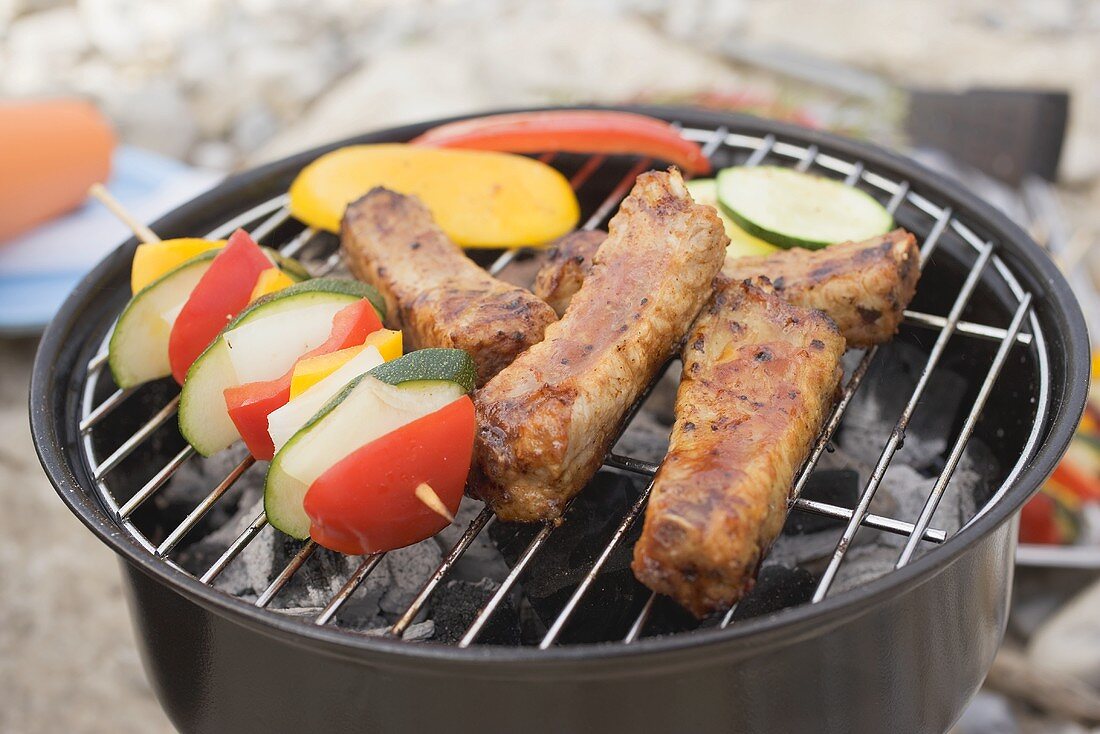 Ribs and vegetables on barbecue out of doors