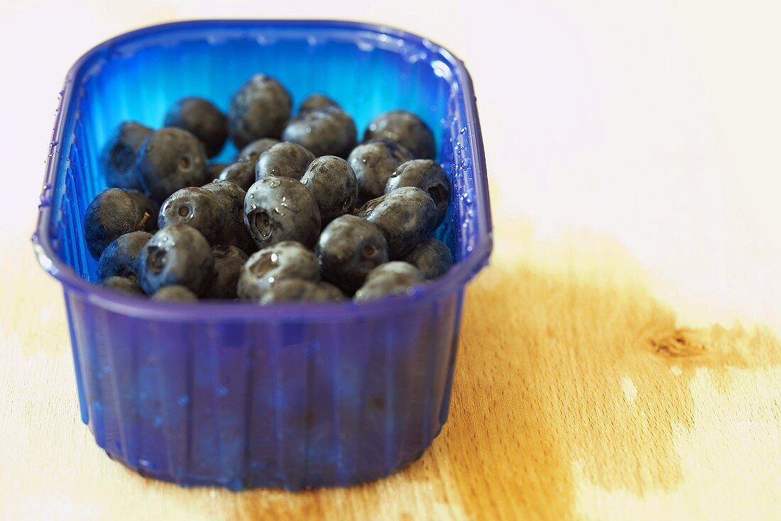 Freshly washed blueberries in a plastic punnet