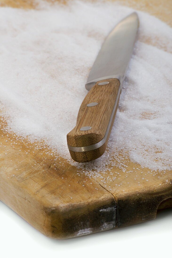 Knife and sugar on chopping board