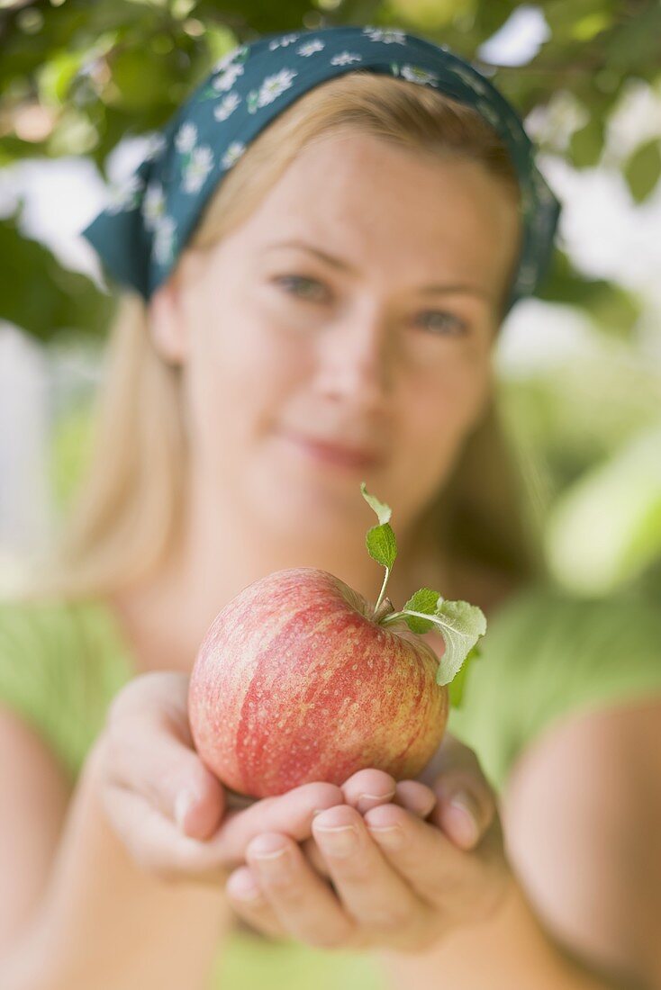 Frau hält einen Apfel