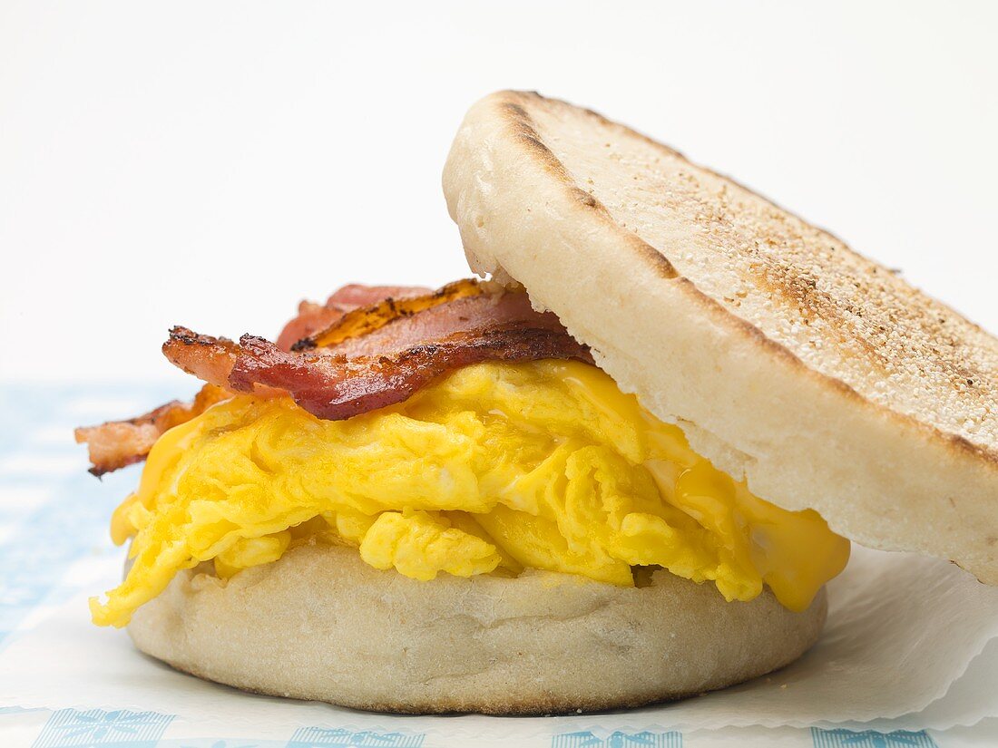 English muffin filled with bacon, scrambled egg & cheese (close-up)